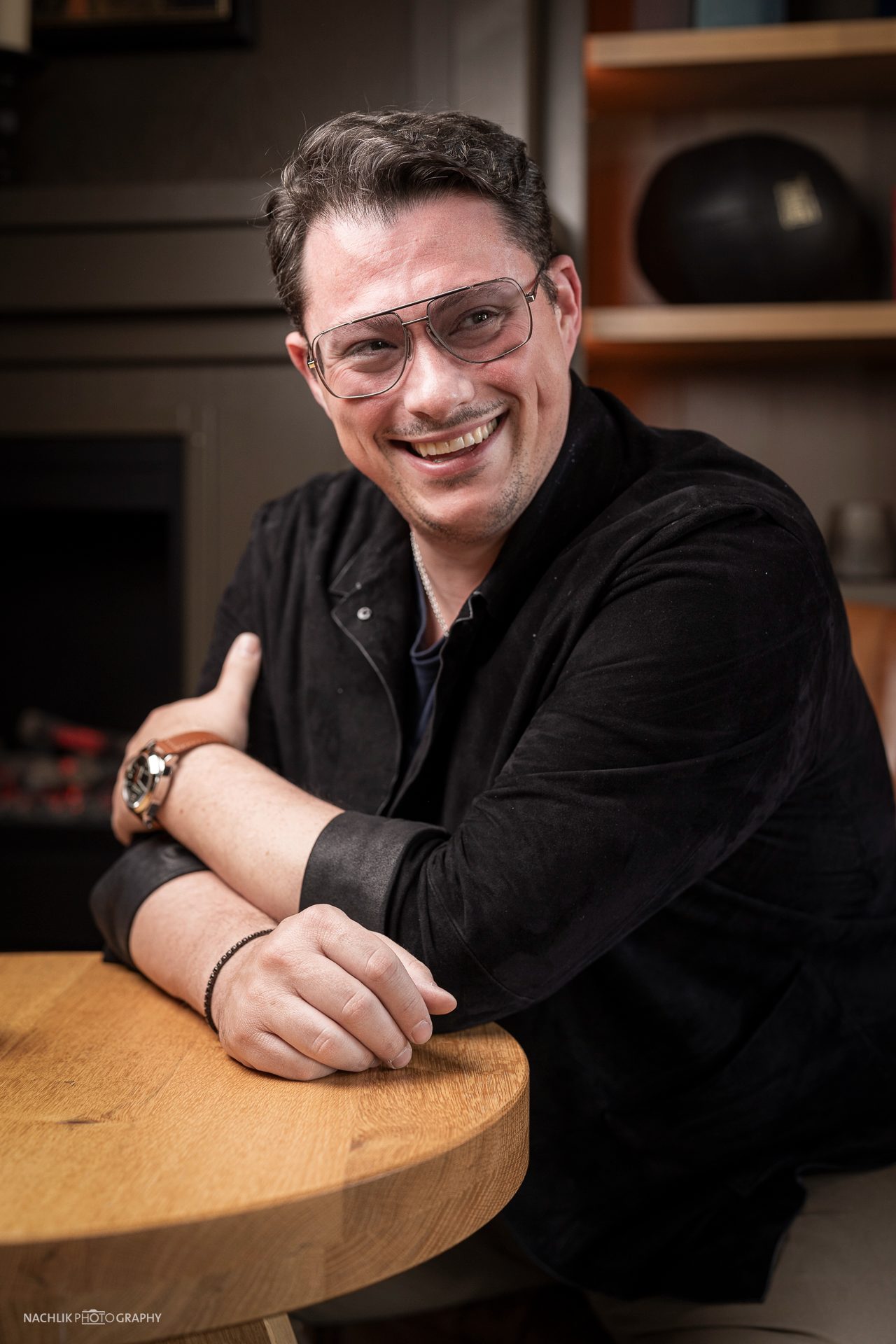 Ricardo Marinello lächelnd an einem runden Bistrotisch