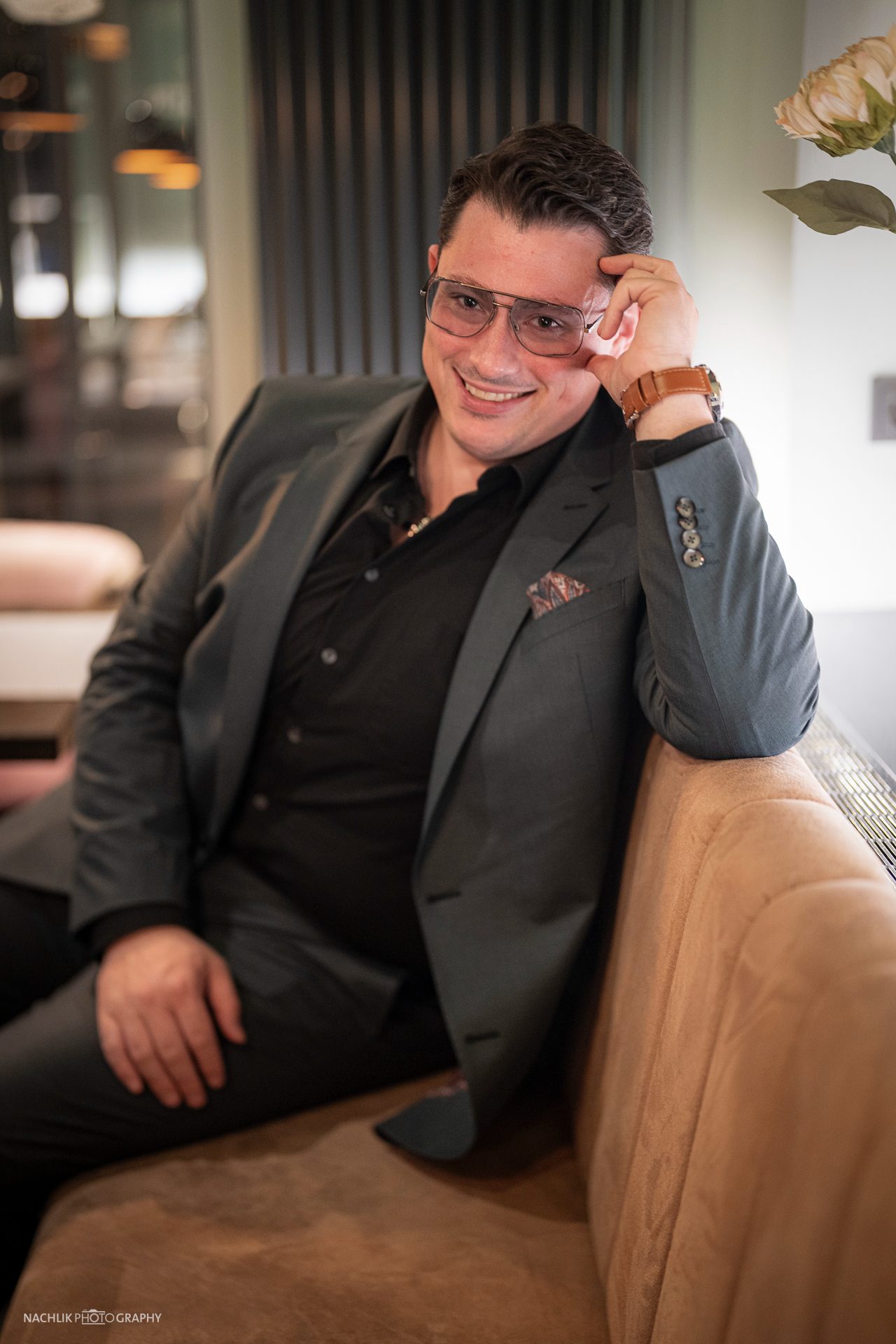 Ricardo Marinello im grauen Anzug lachend in der Lounge