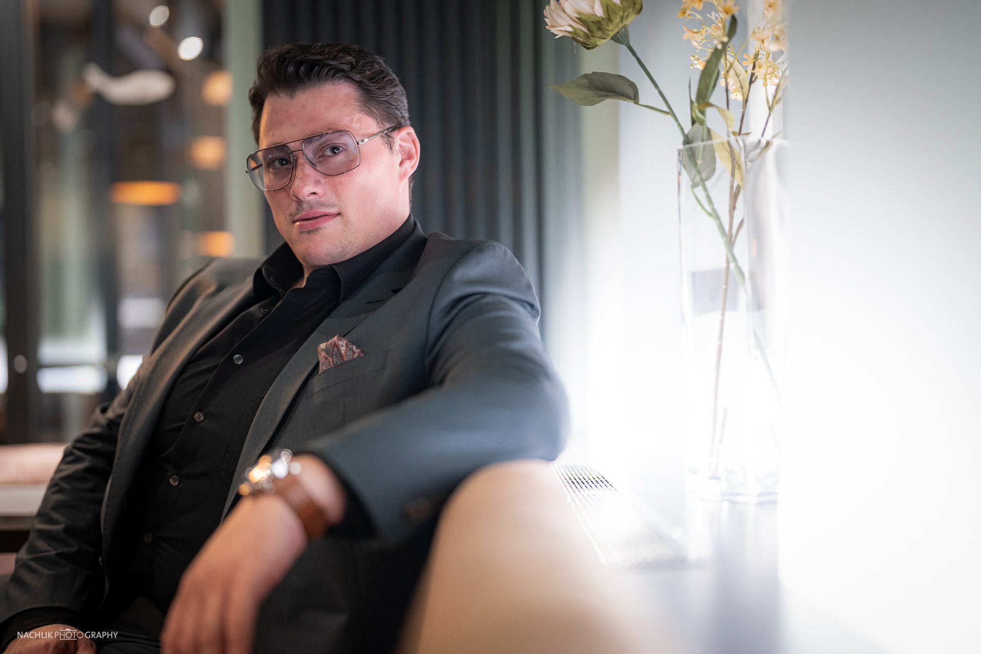 Ricardo Marinello im grauen Anzug sitzend im hellen Fensterlicht