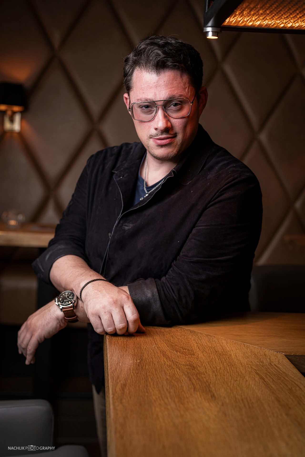 Ricardo Marinello stehend an einem Holztisch, Portrait im warmen Licht