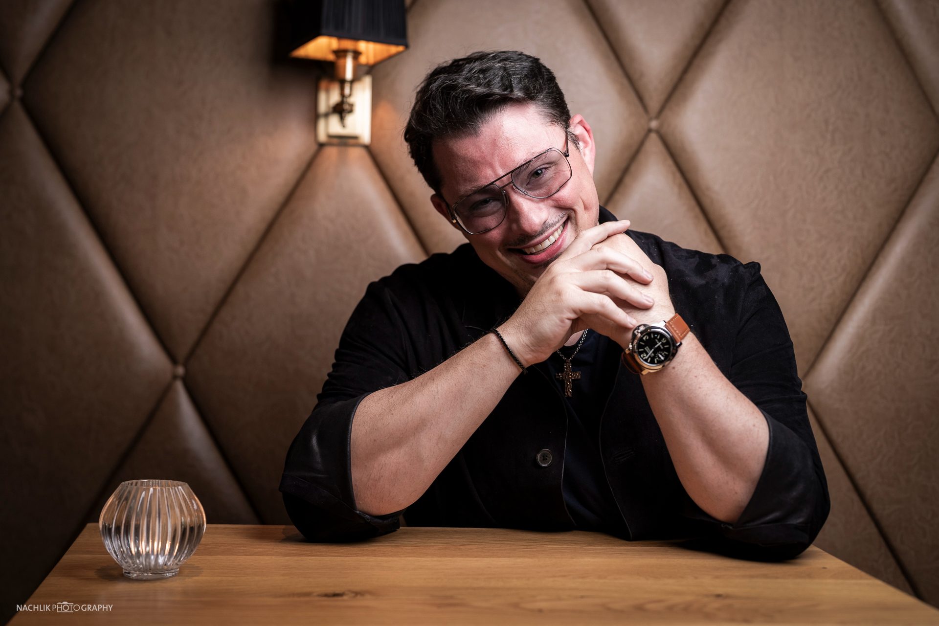 Ricardo Marinello mit gefalteten Händen, Portrait auf der Lederbank