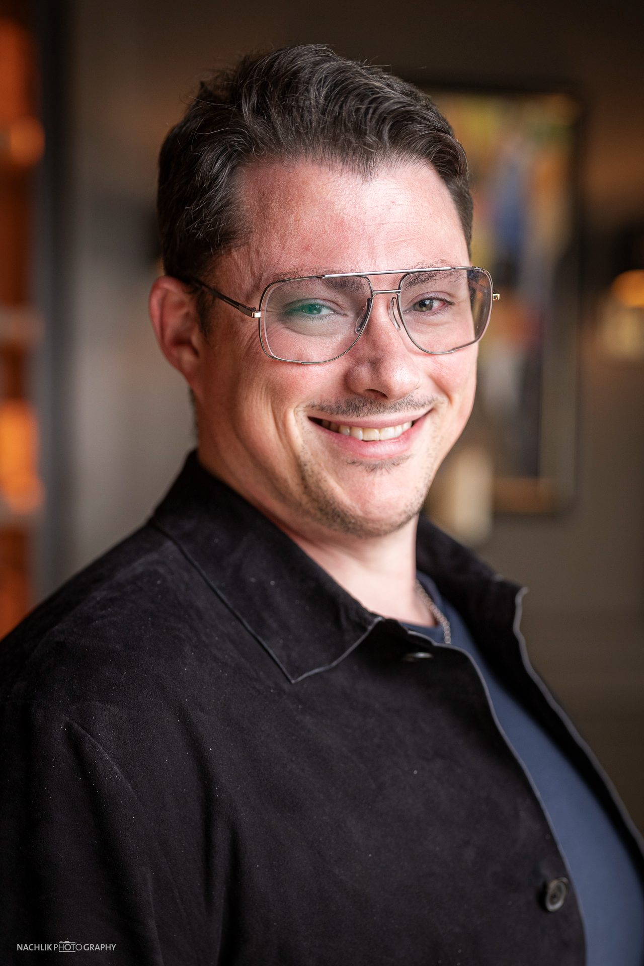 Ricardo Marinello lächelt im schwarzen Hemd, Portrait aus dem Shooting mit Nachlik Photography