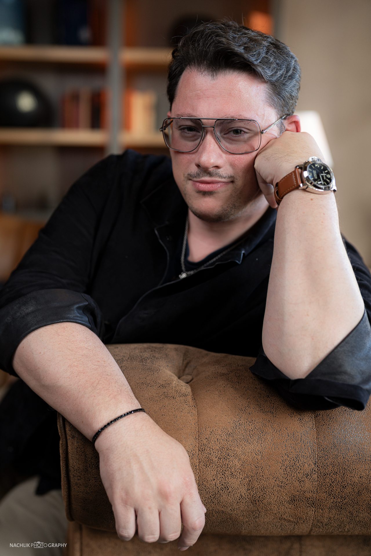 Ricardo Marinello an eine Sessellehne gelehnt, Portrait im Halbdunkel