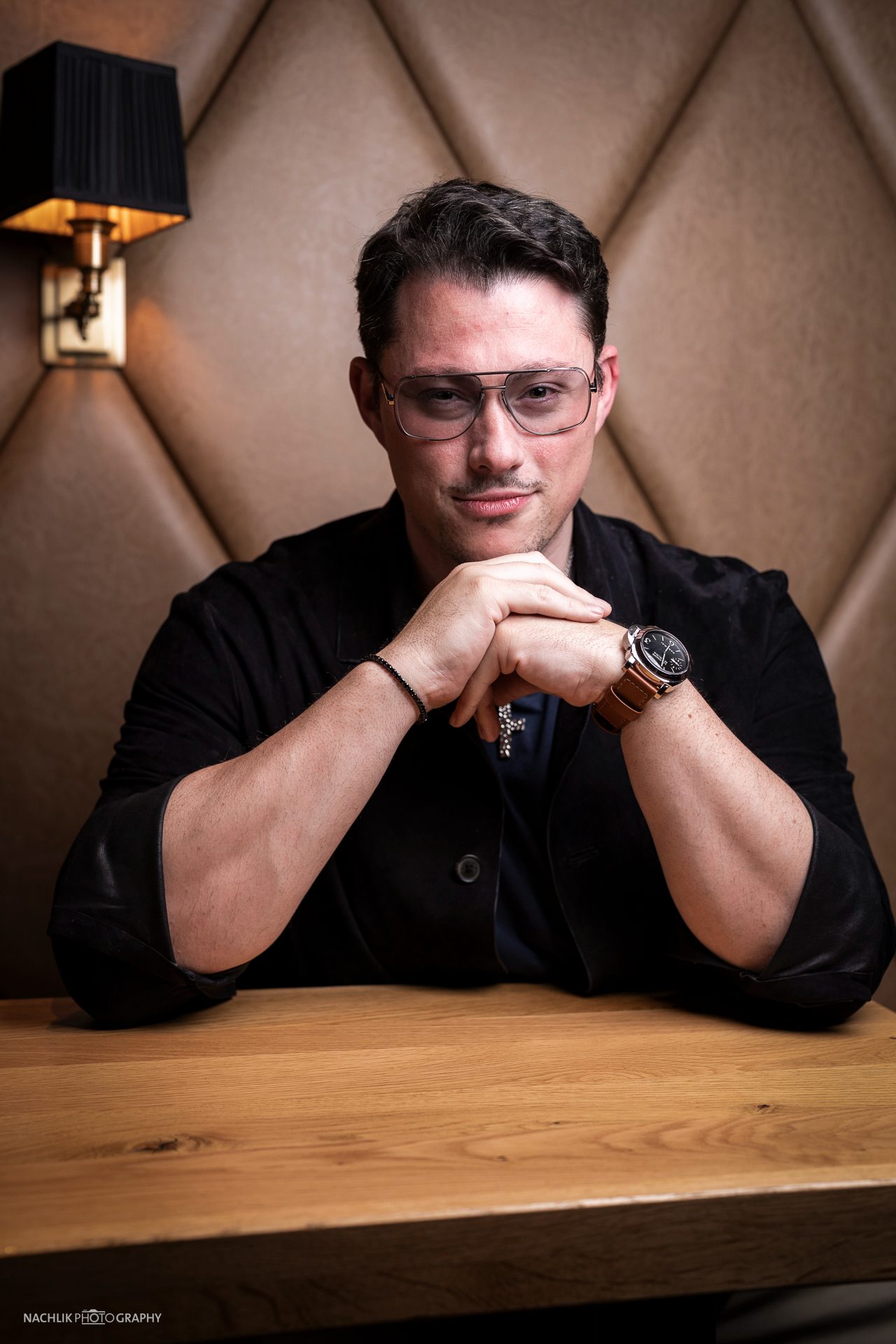 Ricardo Marinello mit gefalteten Händen am Holztisch